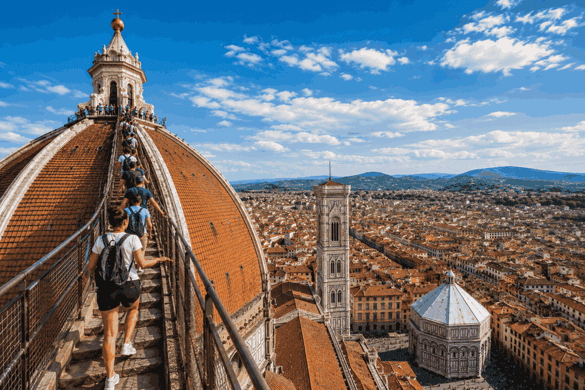 Visitors climbing Brunelleschi’s Dome at Florence Duomo with panoramic views of Giotto’s Bell Tower and the historic city centre.